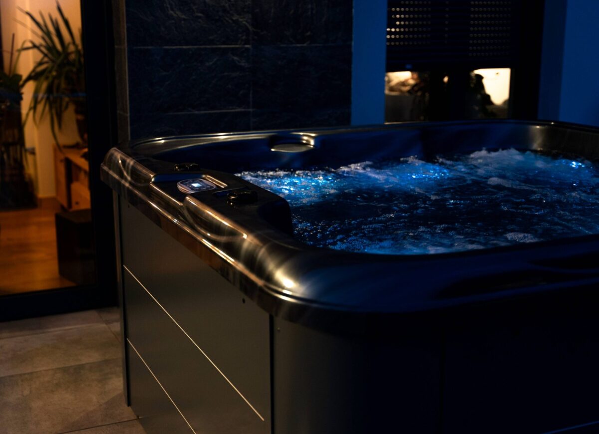 Wanna spa z iluminacją LED, widoczne świecące dysze i podświetlona woda.